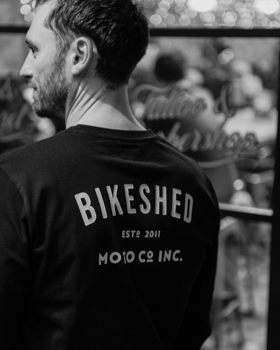 Model wearing Bike Shed Moto Co ESTD Black Longsleeve in the Bike Shed London Restaurant 