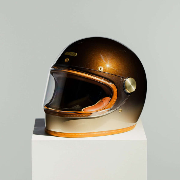 Helmet with a gradient finish on a white pedestal against a light gray background